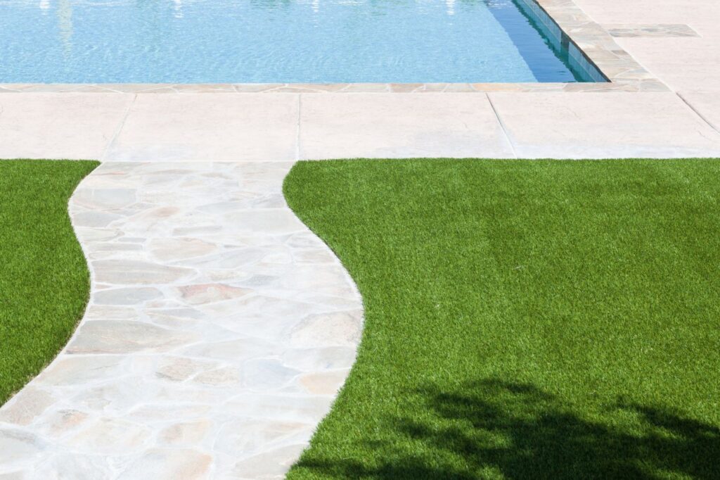 Artificial grass surrounding a backyard pool in Arizona for a clean poolside