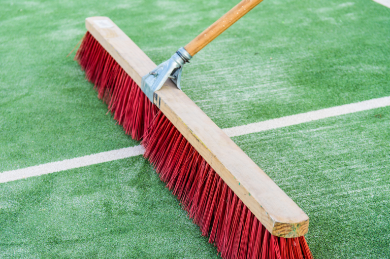 Brushing artificial turf fibers upright as part of routine maintenance