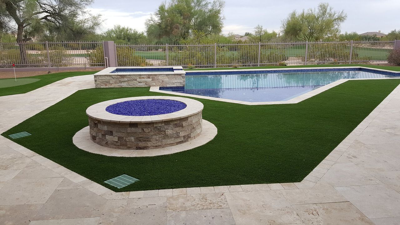 Fire features design by Turfscapes of Arizona featuring a round firepit placed in backyard turf.