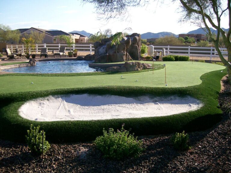 Putting greens installed with white sand trap perfect for chipping golf balls in Arizona backyard.